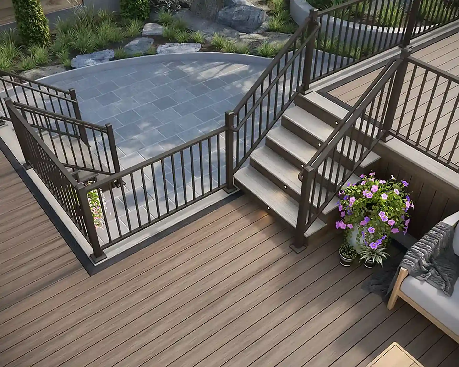 Multi-level composite deck with metal railings, illuminated stairs, and a landscaped patio below - Custom Deck Design and installation near me in Kyle TX