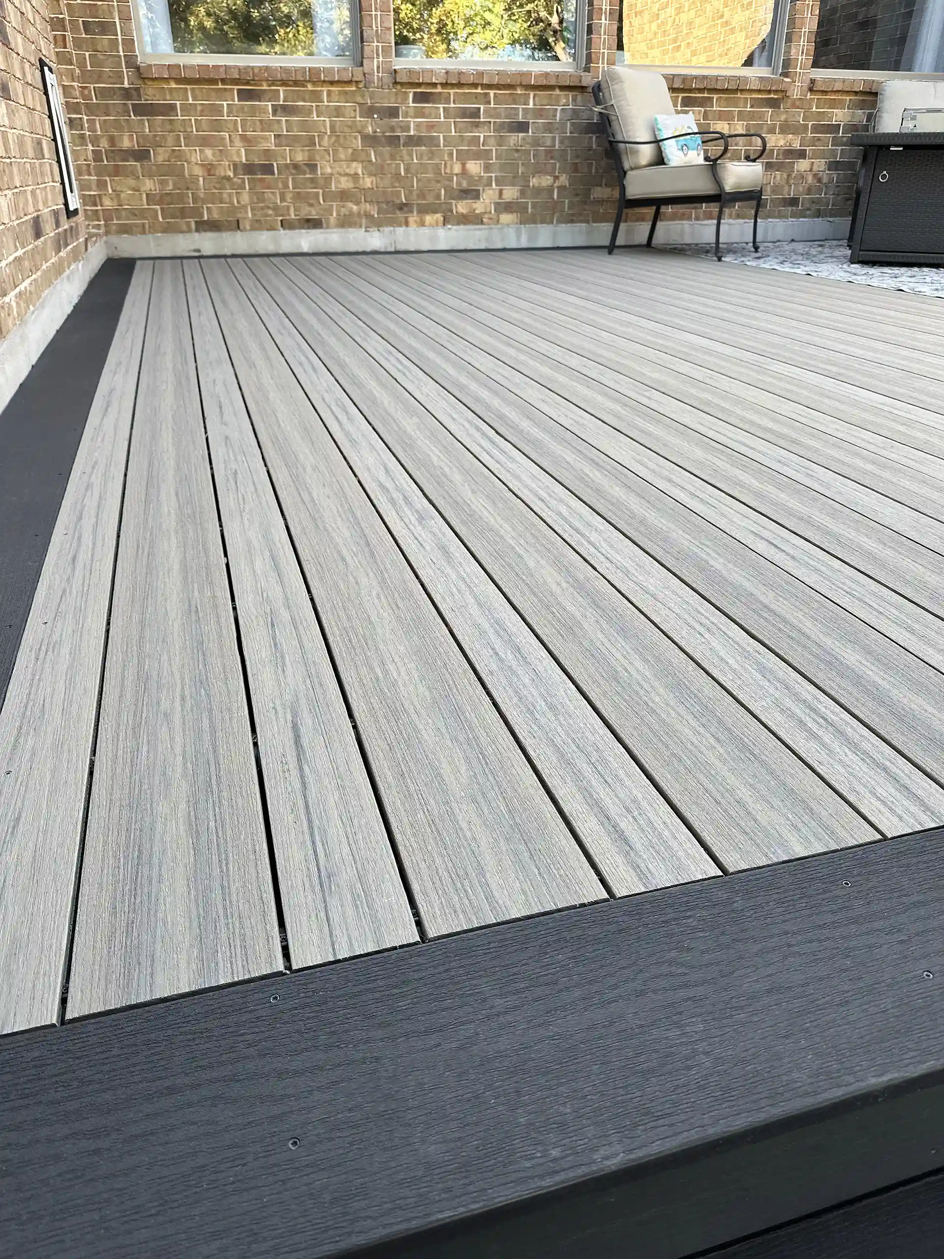 Close-up of a Deckorators® composite deck with a modern, multi-tonal finish and sleek black border