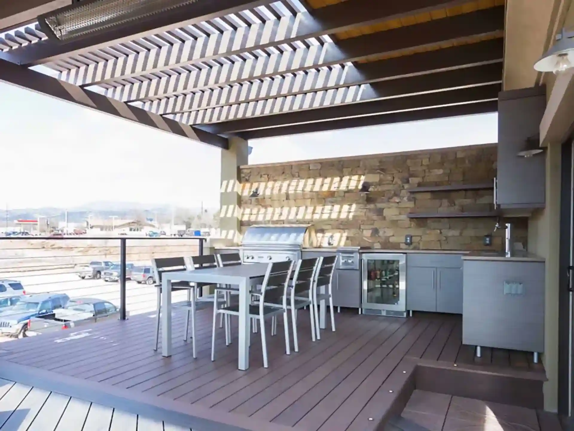 photo of a deck with pergola and outdoor kitchen